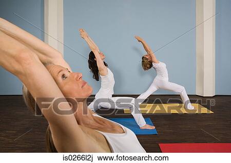 Stock Image - Three women practising yoga. Fotosearch