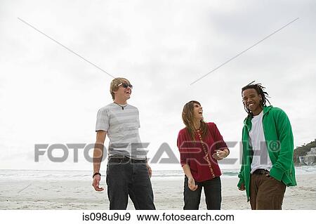 Three young people on beach View Large Photo Image Stock Photo - Three young people on beach. Fotosearch