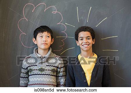 Stock Image - Two boys by a blackboard. Fotosearch