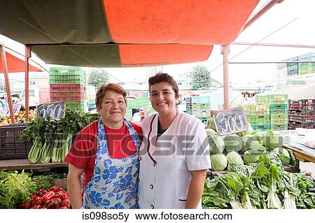 Stock Photo - Two female traders on vegetable stall. Fotosearch