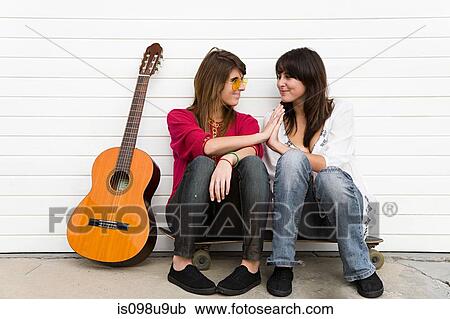 Two girls sitting on floor with guitar View Large Photo Image Stock Image - Two girls sitting on floor with guitar. Fotosearch
