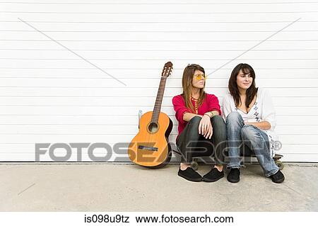 Two girls sitting on floor with guitar View Large Photo Image Stock Photo - Two girls sitting on floor with guitar. Fotosearch