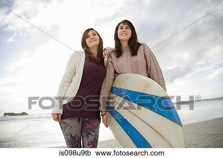 Stock Image - Two girls with surfboard, portrait. Fotosearch