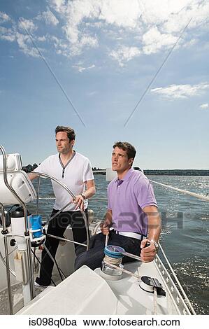 Stock Image - Two men sailing a boat. Fotosearch