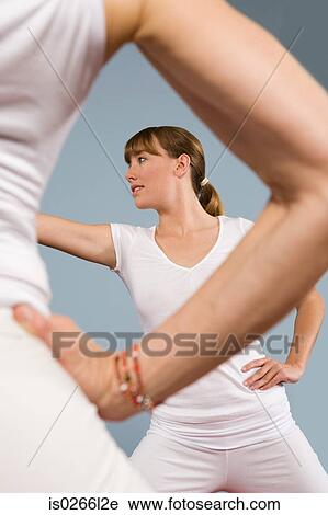 Stock Image - Two women practising yoga. Fotosearch