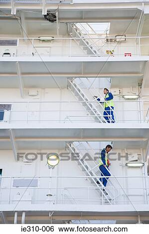 Two workers walking up and down stairs View Large Photo Image Stock Photograph - Two workers walking up and down stairs. Fotosearch