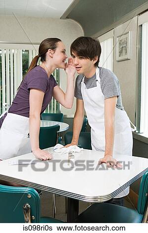 Waitress whispering to colleague View Large Photo Image Stock Photograph - Waitress whispering to colleague. Fotosearch