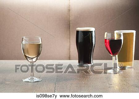 Wine and beer glasses on table in bar View Large Photo Image Stock Photo - Wine and beer glasses on table in bar. Fotosearch