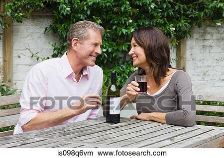 Woman and man sharing bottle of red wine View Large Photo Image Picture - Woman and man sharing bottle of red wine. Fotosearch