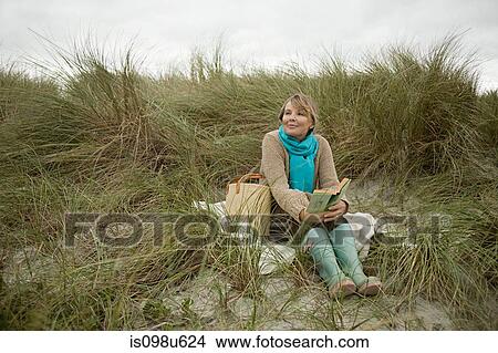 Woman at the coast with a book View Large Photo Image Picture - Woman at the coast with a book. Fotosearch