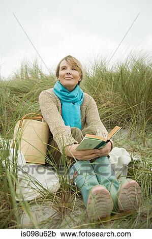 Woman at the coast with a book View Large Photo Image Stock Image - Woman at the coast with a book. Fotosearch