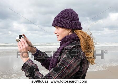 Woman by the sea with camera View Large Photo Image Stock Photo - Woman by the sea with camera. Fotosearch