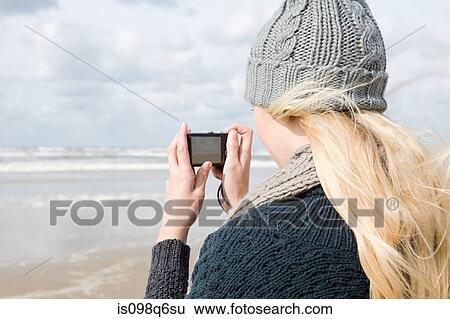 Woman by the sea with camera View Large Photo Image Stock Photograph - Woman by the sea with camera. Fotosearch