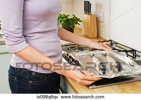 Woman cooking fish View Large Photo Image Stock Photo - Woman cooking fish. Fotosearch