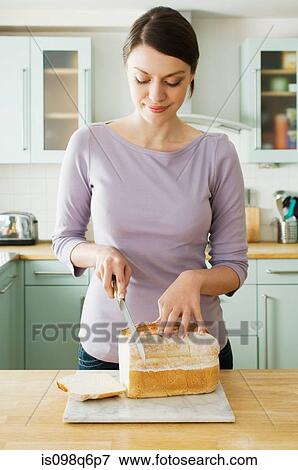 Woman cutting bread View Large Photo Image Stock Photo - Woman cutting bread. Fotosearch