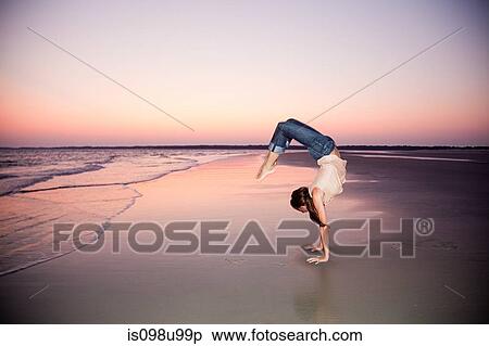 Woman doing a handstand on beach at sunset View Large Photo Image Stock Photography - Woman doing a handstand on beach at sunset. Fotosearch