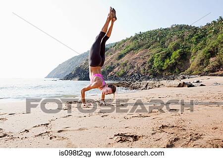 Woman doing handstand on beach View Large Photo Image Stock Image - Woman doing handstand on beach. Fotosearch