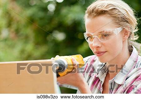 Woman drilling with electric drill View Large Photo Image Picture - Woman drilling with electric drill. Fotosearch