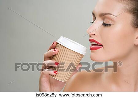 Woman drinking coffee from a paper cup View Large Photo Image Stock Photo - Woman drinking coffee from a paper cup. Fotosearch