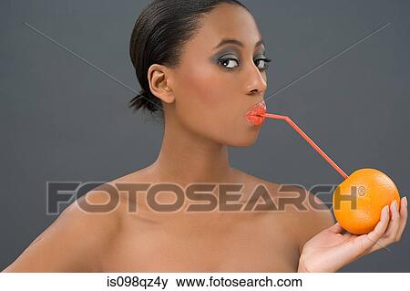 Stock Photo - Woman drinking from an orange. Fotosearch