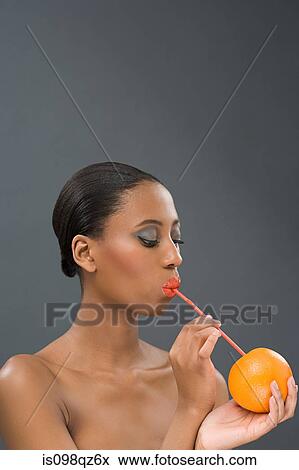Woman drinking from an orange View Large Photo Image Stock Photo - Woman drinking from an orange. Fotosearch