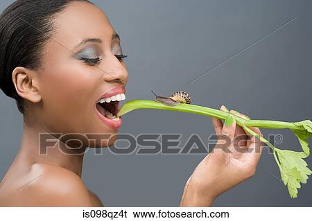 Woman eating a stick of celery with a snail on it View Large Photo Image Stock Photograph - Woman eating a stick of celery with a snail on it. Fotosearch