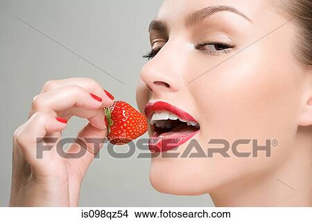 Woman eating a strawberry View Large Photo Image Picture - Woman eating a strawberry. Fotosearch