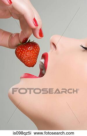 Stock Image - Woman eating a strawberry. Fotosearch