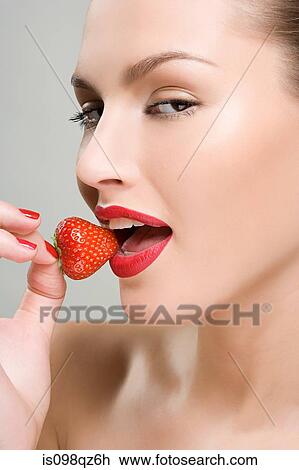 Woman eating a strawberry View Large Photo Image Stock Image - Woman eating a strawberry. Fotosearch