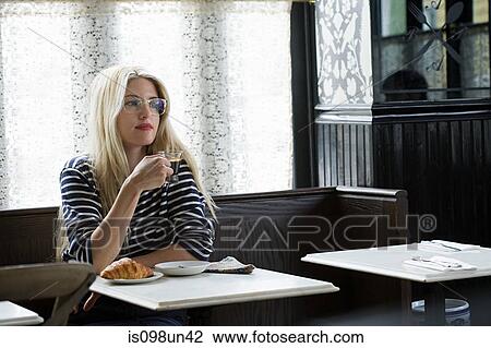 Woman having a drink at coffee shop View Large Photo Image Stock Image - Woman having a drink at coffee shop. Fotosearch