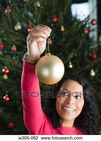 Stock Image - Woman holding a bauble. Fotosearch