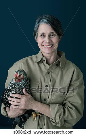 Stock Image - Woman holding a chicken. Fotosearch