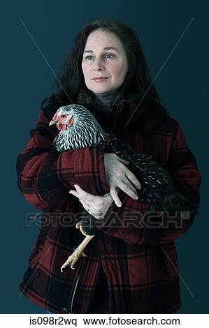 Stock Photography - Woman holding a chicken. Fotosearch