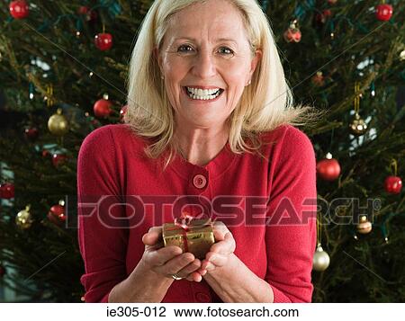 Woman holding a christmas gift View Large Photo Image Stock Image - Woman holding a christmas gift. Fotosearch
