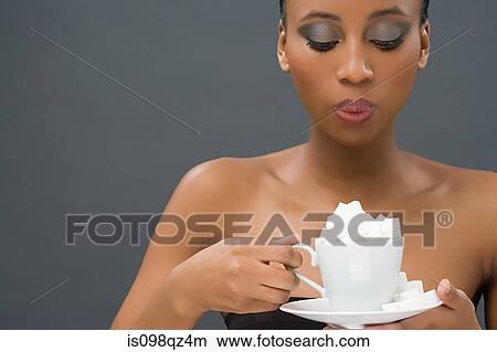 Woman holding a cup of sugar lumps View Large Photo Image Picture - Woman holding a cup of sugar lumps. Fotosearch