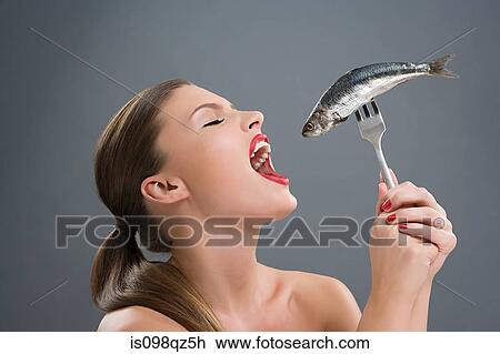 Woman holding a fish on a fork View Large Photo Image Stock Image - Woman holding a fish on a fork. Fotosearch