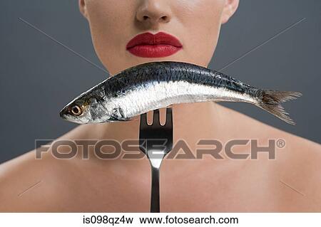 Woman holding a fish on a fork View Large Photo Image Stock Photo - Woman holding a fish on a fork. Fotosearch