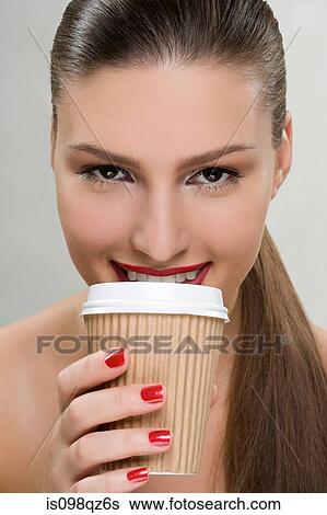 Stock Photograph - Woman holding a paper coffee cup. Fotosearch