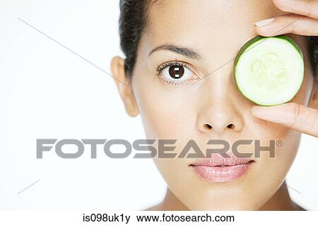 Woman holding cucumber over eye View Large Photo Image Stock Photo - Woman holding cucumber over eye. Fotosearch