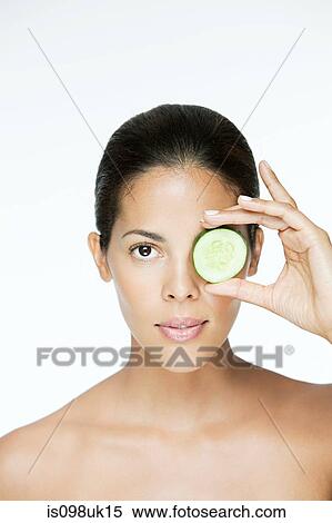 Woman holding cucumber over eye View Large Photo Image Stock Photography - Woman holding cucumber over eye. Fotosearch