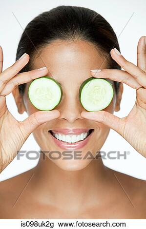 Woman holding cucumber over eyes View Large Photo Image Stock Image - Woman holding cucumber over eyes. Fotosearch