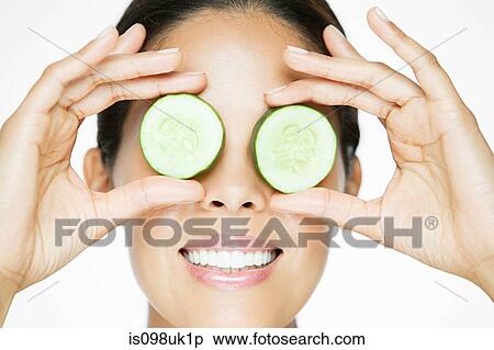 Woman holding cucumber over eyes View Large Photo Image Stock Photography - Woman holding cucumber over eyes. Fotosearch