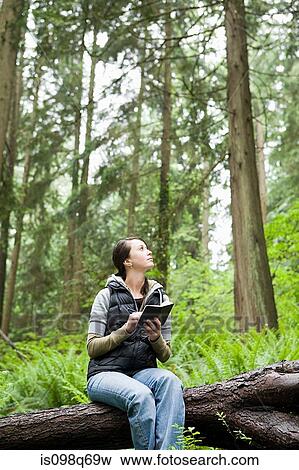 Stock Photo - Woman in forest with notebook. Fotosearch