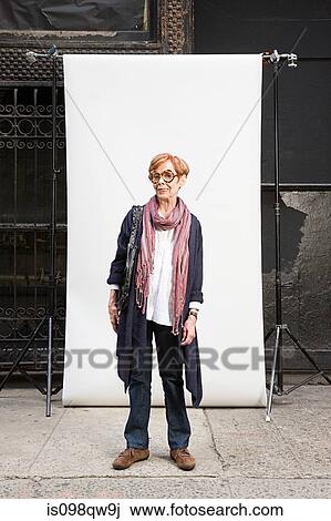 Stock Image - Woman in front of backdrop. Fotosearch