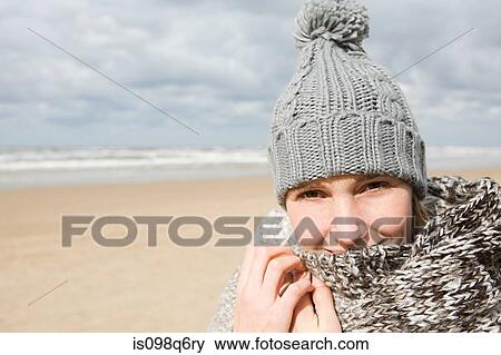 Stock Photo - Woman in hat and scarf by the sea. Fotosearch