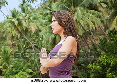 Stock Image - Woman in prayer pose. Fotosearch