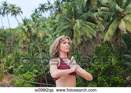 Stock Image - Woman in prayer pose. Fotosearch