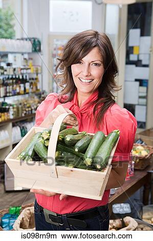 Woman in store with courgettes View Large Photo Image Picture - Woman in store with courgettes. Fotosearch
