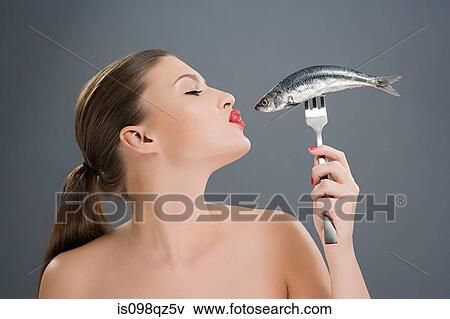 Woman kissing a fish on a fork View Large Photo Image Stock Photo - Woman kissing a fish on a fork. Fotosearch