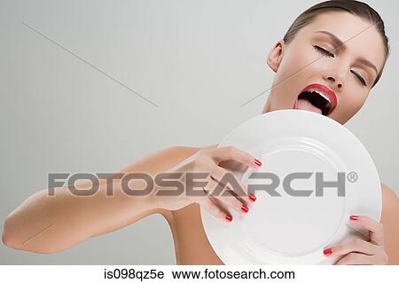 Stock Image - Woman licking a plate. Fotosearch